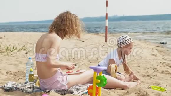 母亲和女儿在阳光明媚的日子在河边野餐视频的预览图