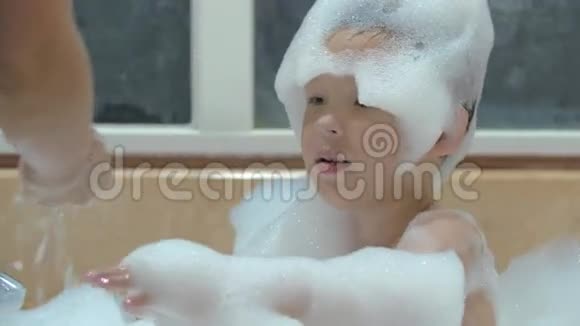 妈妈在洗澡时给孩子洗泡沫视频的预览图
