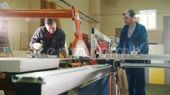 工人们正在家具厂切割电锯上的木刻视频的预览图