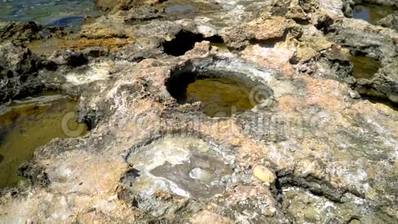 地中海岩石海岸小溪中的盐分沉积视频的预览图