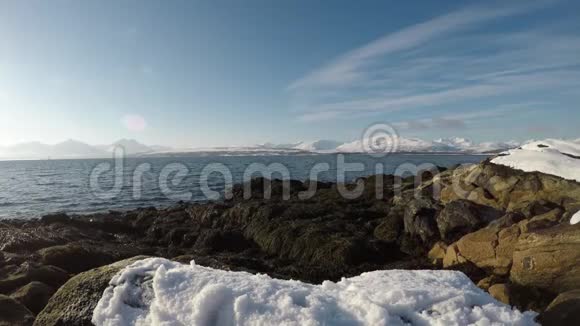 美丽的雪域沙滩湾明亮的阳光远处的雪山背景视频的预览图