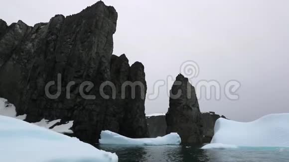 冰川碎片漂浮在海洋中的岩石周围视频的预览图