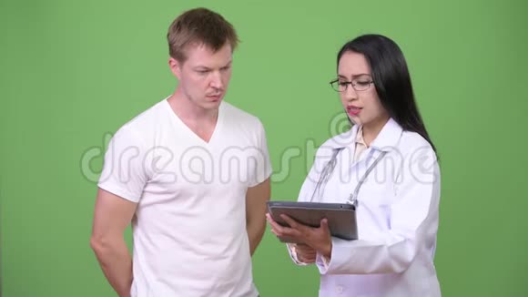 年轻的亚洲女性医生为年轻男性病人提供咨询视频的预览图