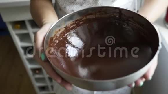 特写旋转融化自制巧克力在妇女手中的碗视频的预览图
