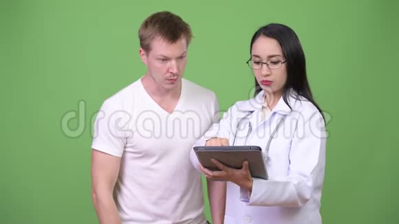 年轻的亚洲女性医生为年轻男性病人提供咨询视频的预览图