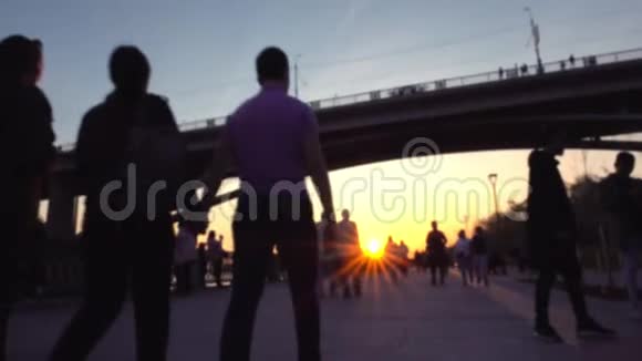 人群走在一条小径上河和桥很近夕阳照在镜头里视频的预览图