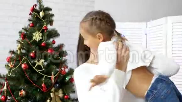 年轻的母亲把她的小女儿变成了背景上的圣诞树视频的预览图