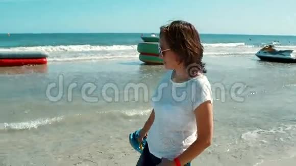 一个穿衣服的女人沿着海岸散步视频的预览图