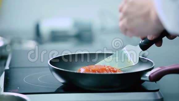 厨师把鱼片放在煎锅上视频的预览图