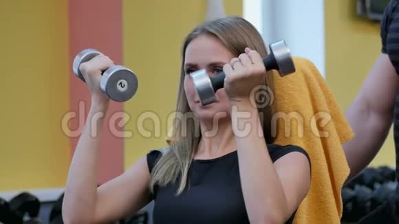 在健身房用哑铃做运动的女人视频的预览图