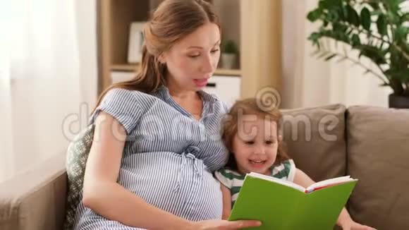 怀孕的母亲和女儿在家看书视频的预览图