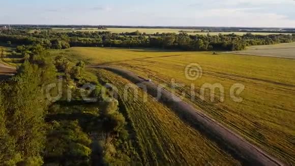 飞越一条乡村景观道路耕地空中拍摄了一条带着车的乡村公路视频的预览图