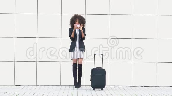 优雅苗条的非洲裔美国妇女带着行李在机场自拍白色纹理墙背景得到的东西视频的预览图