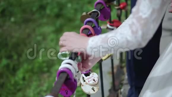 新婚夫妇手中的装饰锁剪辑婚礼象征着永恒的爱锁在新娘和新郎的手中视频的预览图