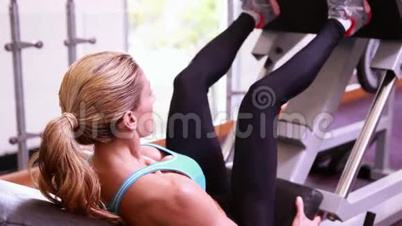 超级健康的女人使用腿部举重机视频的预览图
