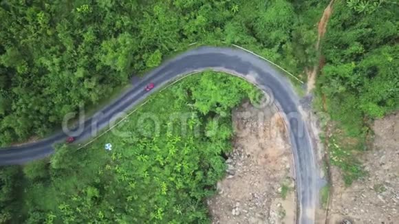 驾驶摩托车的司机在青山旁的弯道上驾驶汽车视频的预览图