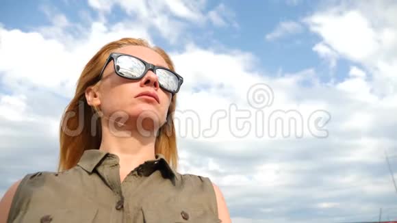 一个女人的特写肖像她站在风中天空中乌云密布头发在风中发展4k缓慢视频的预览图