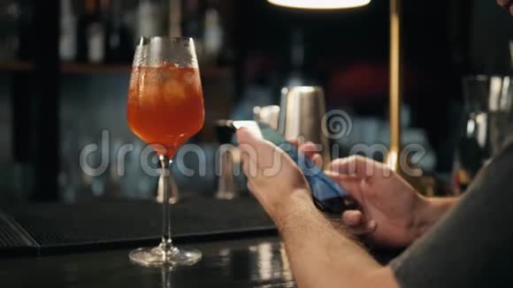 通过NFC在面包店咖啡餐厅酒吧为鸡尾酒柠檬水手机付款的妇女特写视频的预览图