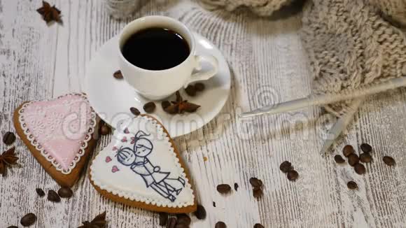 夫妻关系情人节概念一杯咖啡和姜饼干上面有针织针和木纱视频的预览图