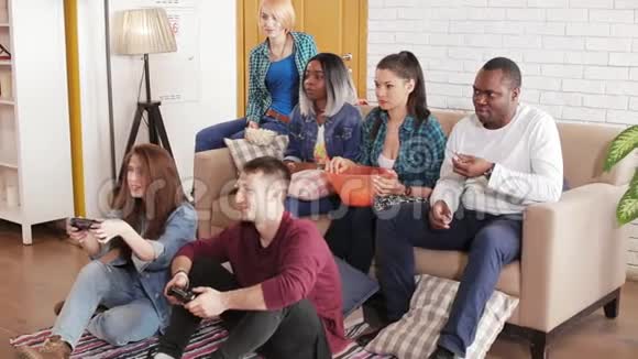 朋友们坐在客厅里玩游戏机视频的预览图