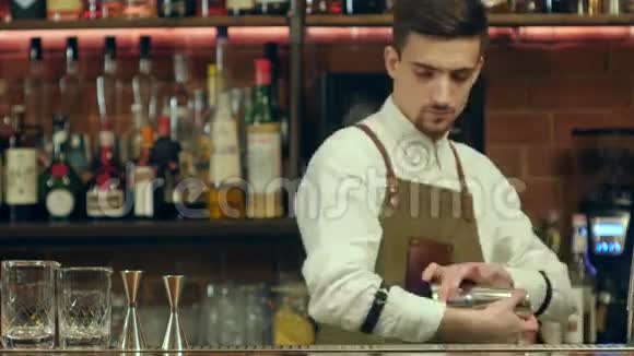 专业酒吧服务员用摇床准备鸡尾酒饮料视频的预览图
