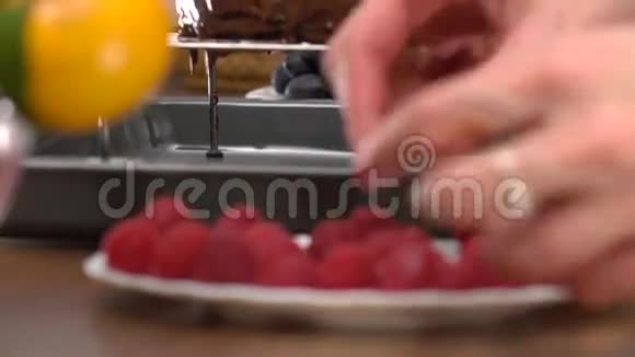 漂亮的女人把树莓放在刚煮好的巧克力蛋糕上4K特写视频视频的预览图