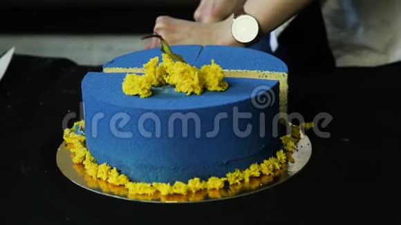 糖果手把蓝色装饰好的蛋糕切成两部分视频的预览图