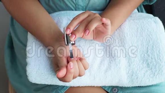 女性在家修指甲时涂基础指甲油女人在家里用指甲漆做装饰指甲家庭视频的预览图