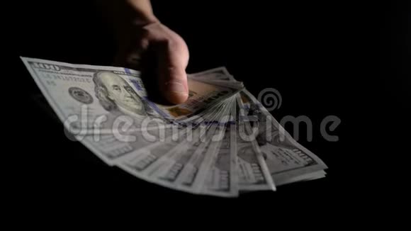 一个人在黑暗中挥舞着一把美元的扇子4K慢动作视频的预览图