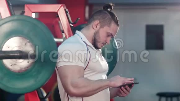 肌肉男在健身间使用电话视频的预览图