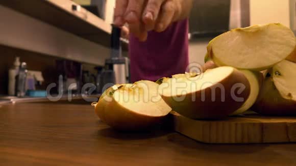 在厨房里用榨汁机的人在家做苹果汁4k特写视频视频的预览图