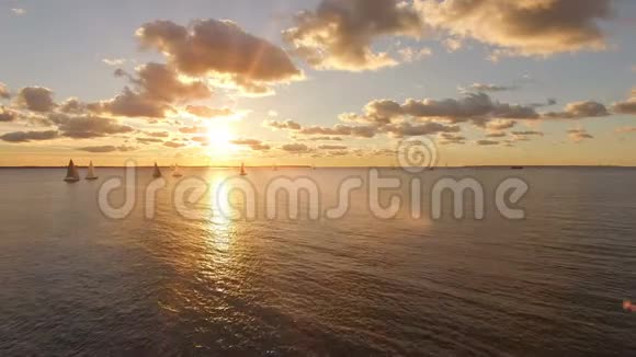 在海上航行的游艇的鸟瞰图和美丽的日落景色公海上的游艇视频的预览图