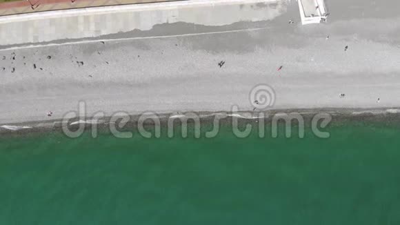人们在海滩和大海上尽情放松的鸟瞰从飞行无人机俯视视频的预览图
