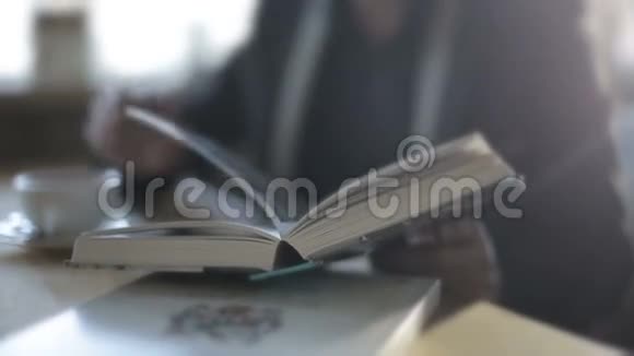 一个在咖啡馆里喝咖啡看书的人慢动作视频的预览图