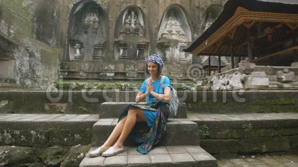 那个穿着蓝色连衣裙戴着头盖帽的女孩在寺庙里神秘的小寺庙在山脚下的巴图卡拉视频的预览图
