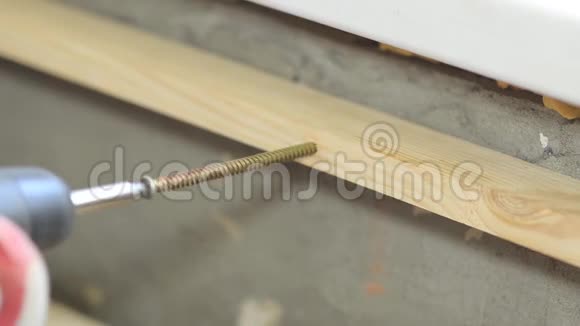 工人拧成木板电动螺丝刀家庭装修视频的预览图