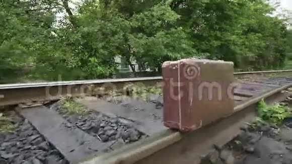 在铁路轨道上行走的带手提箱的人的手视频的预览图