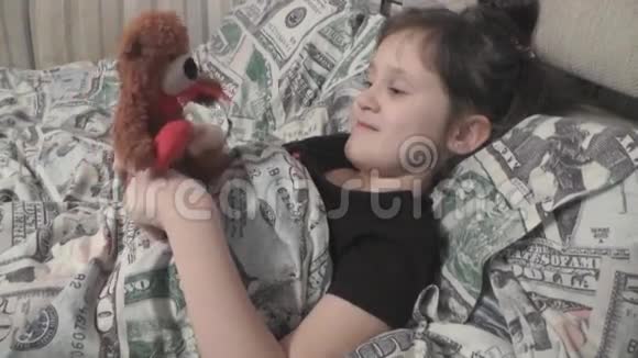 可爱的宝宝躺在床上和泰迪熊玩耍视频的预览图