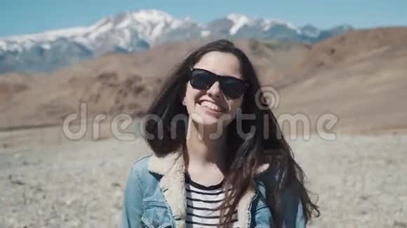 美丽的女孩对大自然微笑和笑在这座山的背景下视频的预览图