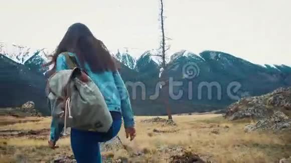 徒步旅行者停下来看风景徒步旅行期间在山区户外活动的徒步女孩视频的预览图