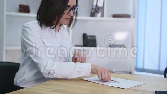 女商人在纸质文件或合同上签字的特写镜头视频的预览图