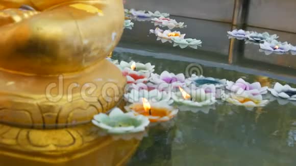 雕刻的佛像周围漂浮着五颜六色的蜡烛形状像莲花视频的预览图