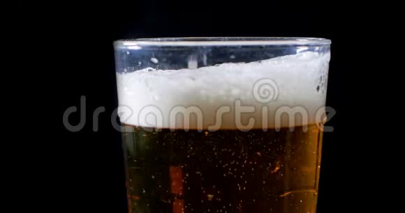 在黑色背景的一品脱杯中倒入啤酒视频的预览图
