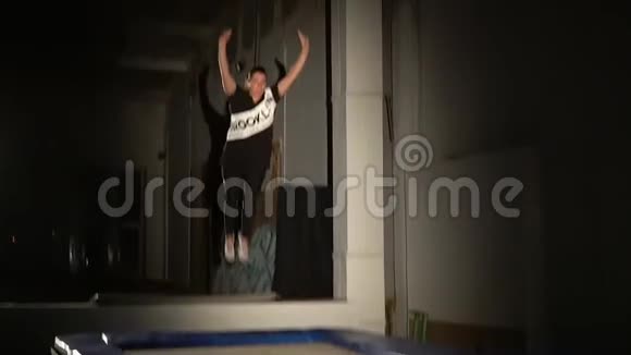 穿着运动服的布鲁内特在蹦床上跳跃动作缓慢视频的预览图