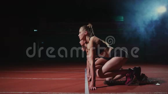 女运动员在赛跑前在跑道上热身在慢动作中视频的预览图