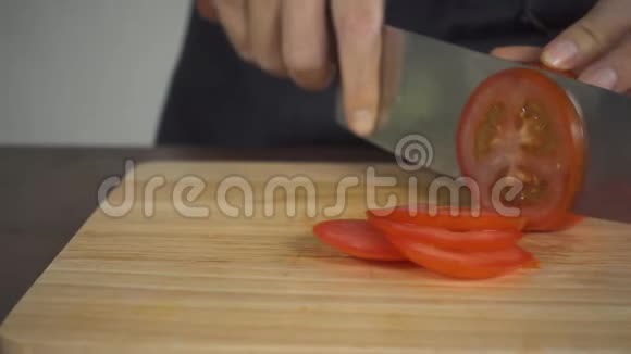 慢动作关闭首席女人做沙拉健康食品和切番茄在切割板在厨房视频的预览图