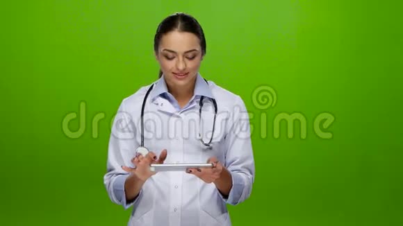 女医生微笑着在平板电脑上工作视频的预览图