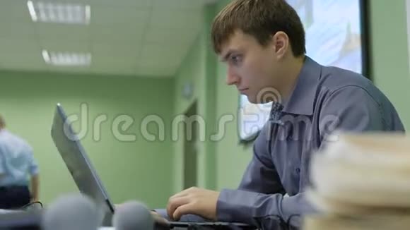 在观众中使用笔记本电脑的年轻人刚开始的商人仔细研究笔记本电脑上的信息视频的预览图
