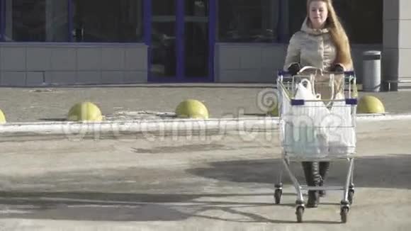 年轻女孩从超市买东西时拿出手推车还有股票录像视频的预览图