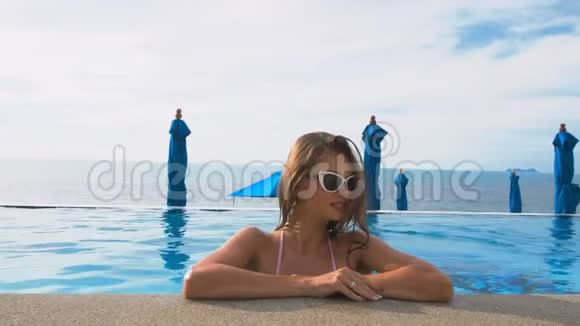 年轻白种人女子在游泳池微笑的肖像完美假期概念视频的预览图